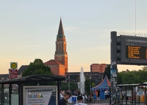 Die Haltestelle am Lorentzendamm noch mit dem alten Haltestellenschild und dem Rathaus im Hintergrund