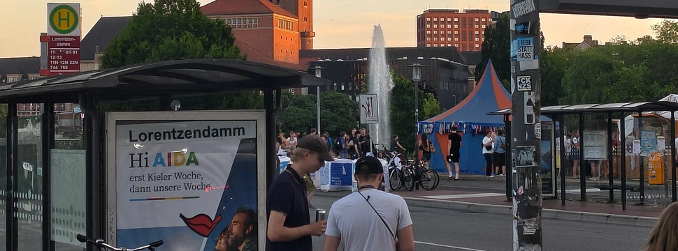 Die Haltestelle am Lorentzendamm noch mit dem alten Haltestellenschild und dem Rathaus im Hintergrund