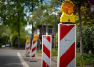 Rot-weiße Leitbaken auf einer Straße, die auf eine Baustelle hinweisen
