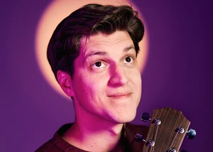 Ein Mann mit dunklen Haaren vor einem violetten Hintergrund