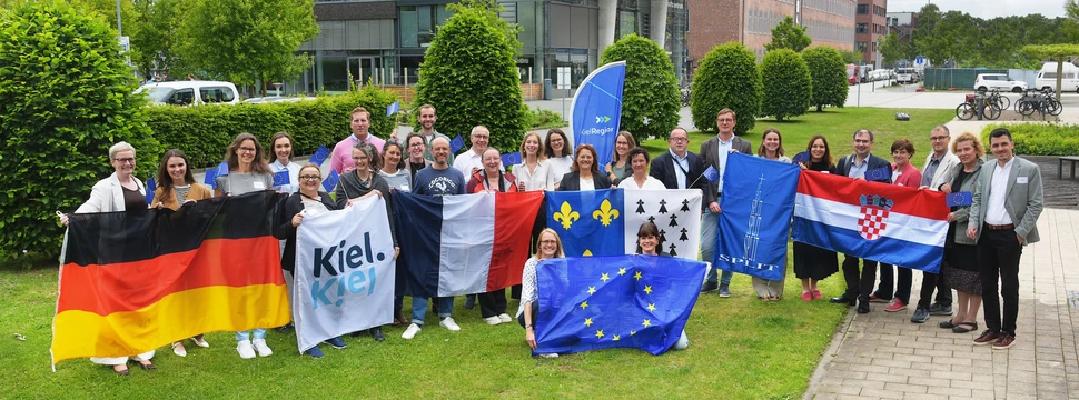 Versammlung von Menschen die verschiedene Flaggen hochhalten