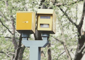 Ein Blitzer an einer Straße mit Bäumen im Hintergrund