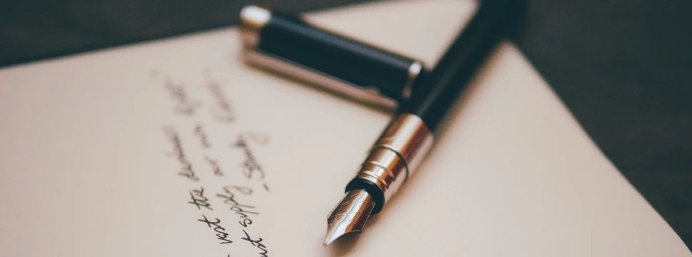 Auf einem Zettel ist ein Gedicht geschrieben, daneben liegt ein Füller