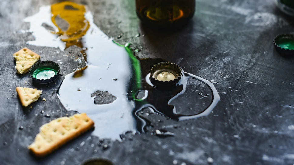 Auf einem Tisch sieht man Bierdeckel und Spuren von Alkohol