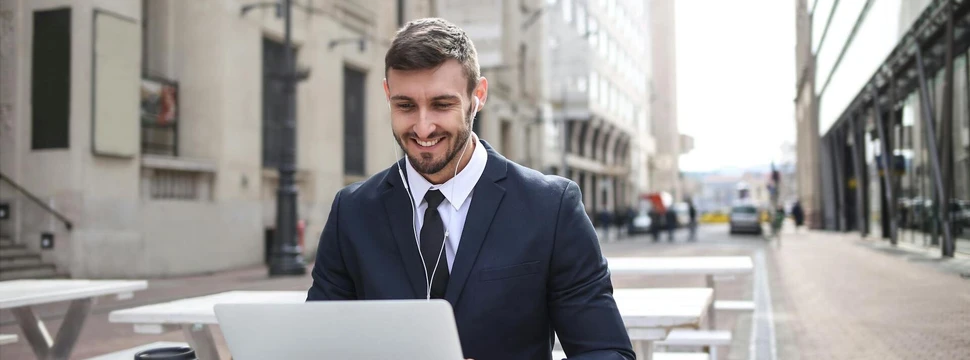 Mann im schwarzen Anzug mit Macbook, © pexels.com