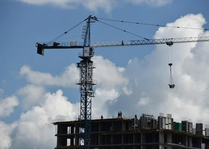 Ein hoher Kran mit blauem Himmel und Wolken im Hintergrund