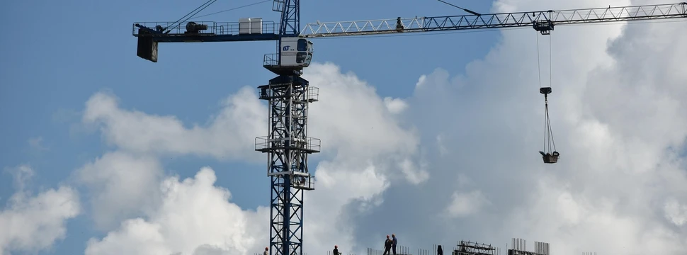 Ein hoher Kran mit blauem Himmel und Wolken im Hintergrund