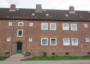 Ein typisches Reihenhaus in Kiel Elmschenhagen Ein Haus aus dem 20. Jahrhundert bestehend aus Backsteinen und Fenstern und einem Fahrrad davor