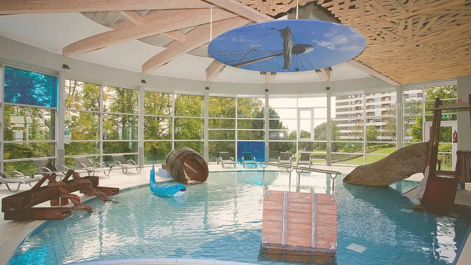 Innenansicht eines Schwimmbads mit Rutschen und Schwimmreifen im Becken