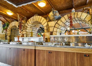 Mehrere Metallbehältnisse mit Essen darin vor Torbögen aus Stein