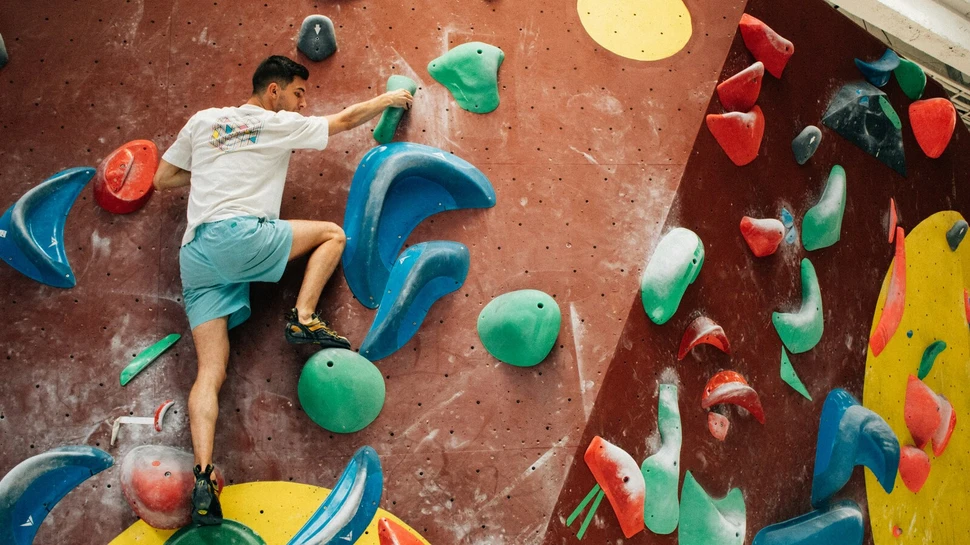 Mann klettern ohne Sicherung eine Kletterwand mit Hindernissen hoch