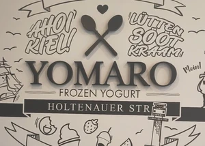 Innenansicht des Yomaro in Kiel Ein Aufkleber an einer Wand, auf dem "Yomaro Frozen Yoghurt" steht