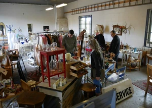 Eine Gruppe von Menschen zwischen Möbel und Gegenständen.