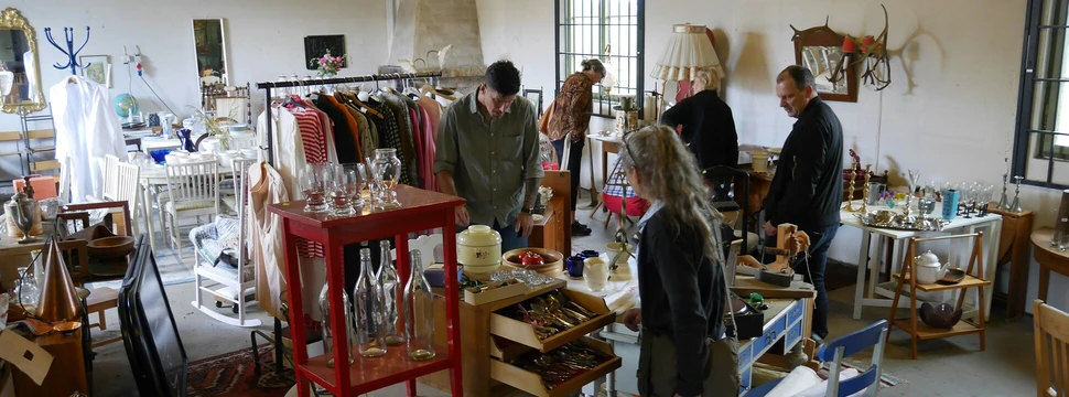 Eine Gruppe von Menschen zwischen Möbel und Gegenständen.