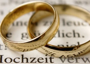 zwei Trauringen liegen auf einer Traurede