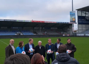 Mehrere Menschen auf dem Rasen des Holsteinstadions in Kiel mit Fußbällen in der Hand