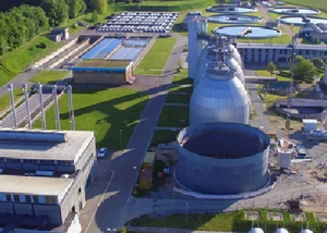 Die metallischen Behältnisse des Klärwerks in Bülk aus der Luft gesehen mit Wasserbecken daneben
