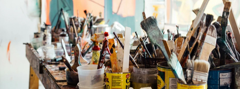 Viele unterschiedliche Pinsel sind in unterschiedlichen Dosen und Behältnissen