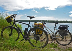Zwei Fahrräder stehen am See, gesattelt mit Gepäcktaschen