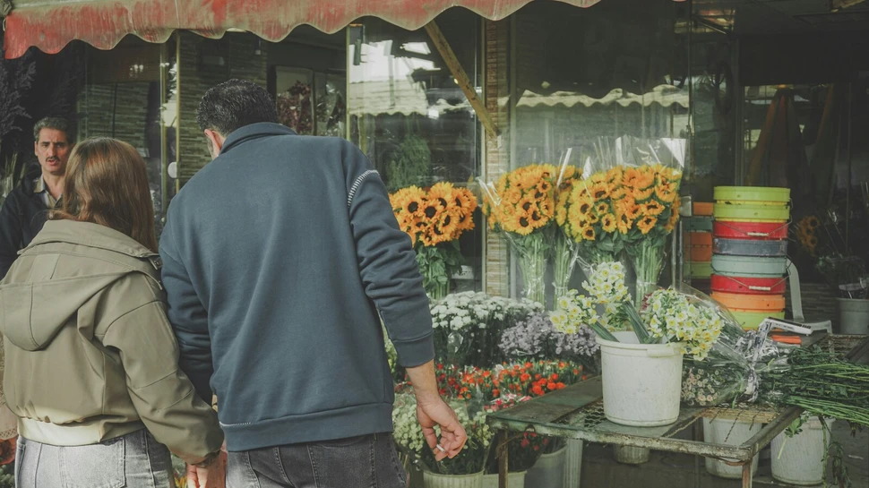 Ein Paar stöbert an einem Blumenstand
