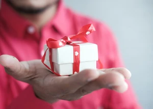 Mann hält Geschenk in der Hand