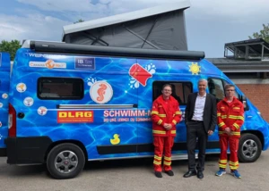 Ab sofort mit dem Schwimm-Mobil im Dienste der Anfänger-Schwimmausbildung im Land unterwegs: Die Bundesfreiwilligen-Dienstleistenden Henrik Thomsen (links) und Jakob König (rechts) mit dem Vorstandsvorsitzenden der IB.SH, Erk Westermann-Lammers, © DLRG SH e.V.