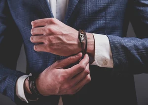 Elegante Lederarmbänder für Männer drücken auch Persönlichkeit aus Mann im Anzug trägt Lederarmband mit silberner Schließe