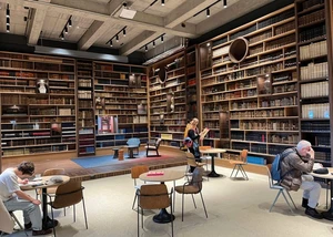 Innenansicht der Landesbibliothek Schleswig-Holstein, bei der mehrere Menschen vor Bücherregalen an Tischen sitzen