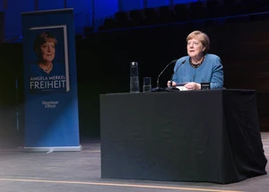 Angela Merkel während der Lesung auf der Bühne des Konzerthauses, neben sich einen Banner stehend mit der Aufschrift "Freiheit", dem Titel ihres Buches