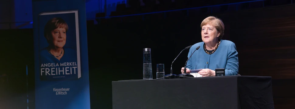 Angela Merkel während der Lesung auf der Bühne des Konzerthauses, neben sich einen Banner stehend mit der Aufschrift "Freiheit", dem Titel ihres Buches