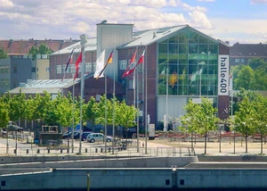 Die Halle 400 vom Hauptbahnhof aus gesehen Eine Halle in Kiel direkt am Ufer der Förde gelegen mit Häusern und Bäumen im Hintergrund