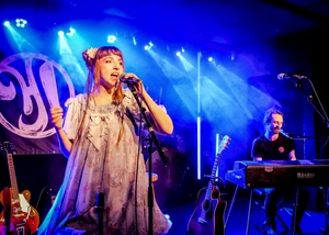 Hey Julis! während eines Auftritts Eine Band auf einer Bühne mit Beleuchtung im Hintergrund