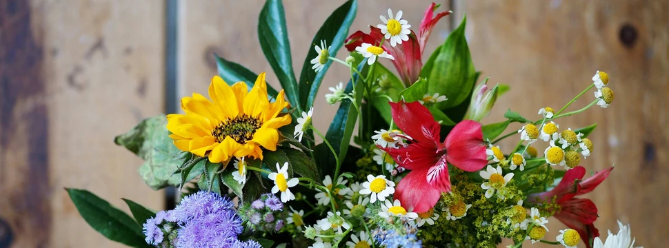 Verschiedene Blumen befinden sich in einer Vase. Das Foto wurde von oben aufgenommen.