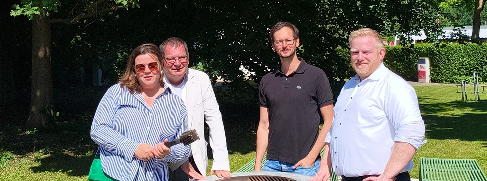 Vier Menschen bei der Vorstellung des neuen Grillplatzes am Falckensteiner Strand, der hoffentlich ordentlich genutzt wird