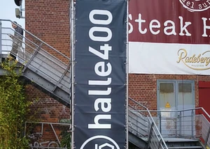 Ein Banner vor der Halle 400 bei der Wiedereröffnung Ein Banner vor einem Haus aus Backsteinen in Kiel mit der Aufschrift "Halle 400"