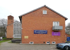 Bugenhagenkirche Kiel mit Gemeindehaus und Veranstaltungsbannern. Backsteinkirche mit Gemeindesaal und Bannern für Kinderkirche und Zeltlager in Kiel.