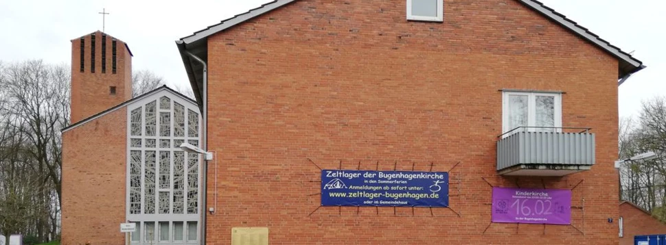 Backsteinkirche mit Gemeindesaal und Bannern für Kinderkirche und Zeltlager in Kiel.