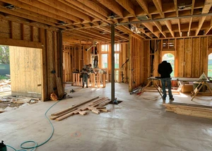 Zwei Menschen auf einer Baustelle, auf der ein Haus gebaut wird