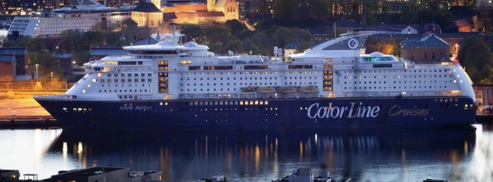 Großes Kreuzfahrtschiff "Color Fantasy" bei Nacht im beleuchteten Stadt­hafen