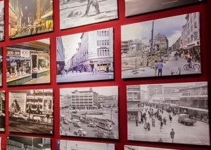 Mehrere Bilder an einer Wand, die verschiedene Epochen der Zeitgeschichte zeigen