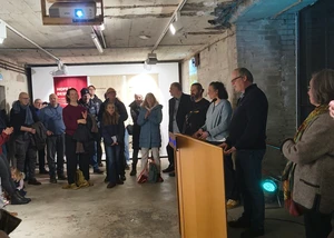 Mehrere Menschen in den Räumlichkeiten des Bunker-D in Kiel bei einer Ausstellungseröffnung