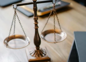 Eine Waage auf einem Holztisch, die die ausgeglichene Gerechtigkeit symbolisiert