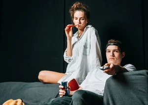 Zwei junge Menschen auf einer Bühne, die ein Theaterstück in Kostüm aufführen