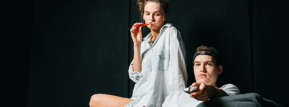 Zwei junge Menschen auf einer Bühne, die ein Theaterstück in Kostüm aufführen