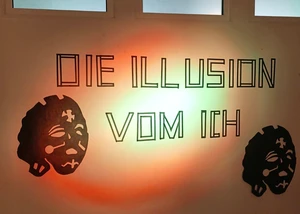 Der Schriftzug "Die Illusion vom Ich", die das Motto der aktuellen Ausstellung im Kunstraum B darstellt, an einer weißen Wand