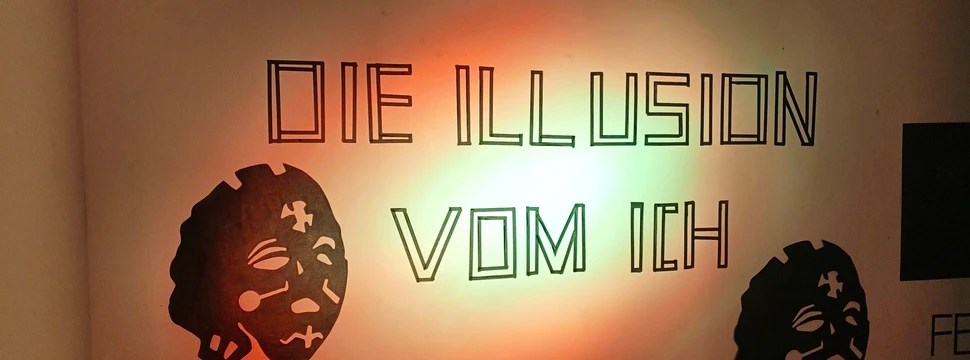 Der Schriftzug "Die Illusion vom Ich", die das Motto der aktuellen Ausstellung im Kunstraum B darstellt, an einer weißen Wand