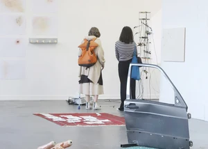 Zwei Personen sehen sich Kunst an der Wand an
