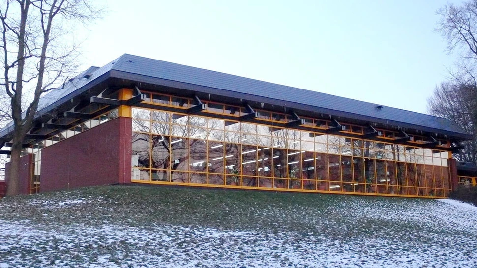 Ein Gebäude mit einer hohen Fensterfront und mit Schnee davor