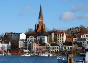Der Hafen der Stadt Flensburg Ansicht einer Kirche in Flensburg mit dem Hafen und anderen alten Häusern im Vordergrund