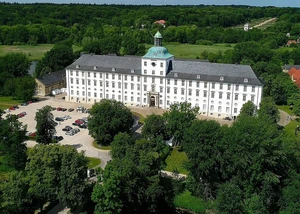 Schloss Gottorf aus der Luft gesehen Ein weißes Schloss aus der Luft gesehen mit Bäumen und Wasser im Hintergrund